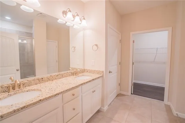 a spacious bathroom with a granite countertop sink a mirror and a shower
