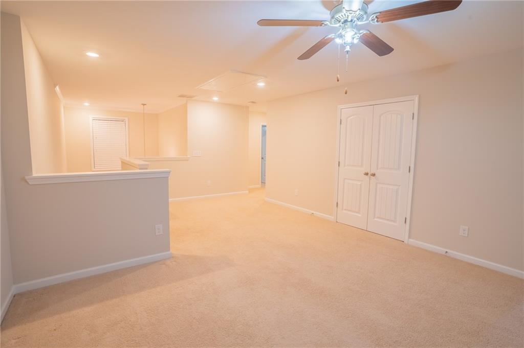 2420 Boxwalking Court Cumming, GA 30040 - Photo 30 of 42 an empty room with chandelier fan and windows