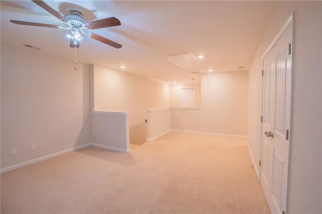 en empty room with fan and a ceiling fan