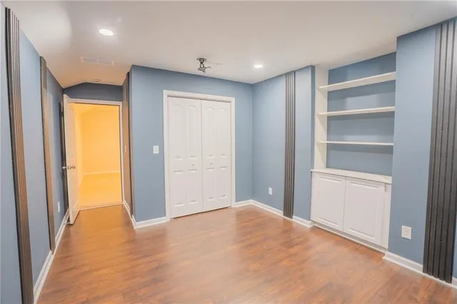 a view of an empty room with closet and a window