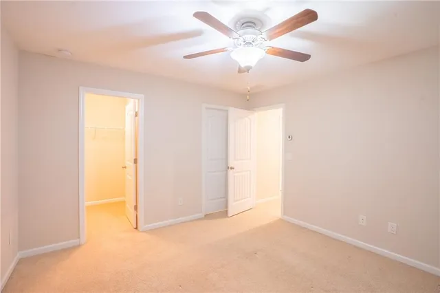 an empty room with a ceiling fan and a window