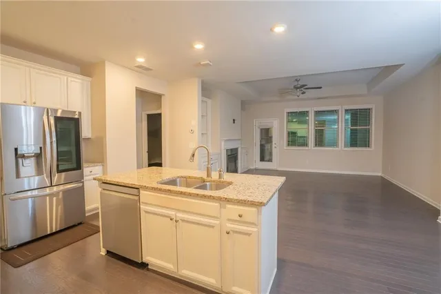 a kitchen with stainless steel appliances granite countertop a refrigerator and a sink