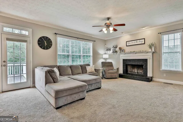a living room with furniture a fireplace and a chandelier