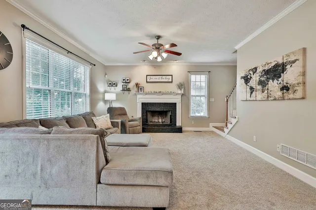 a living room with furniture and a large window with wooden floor