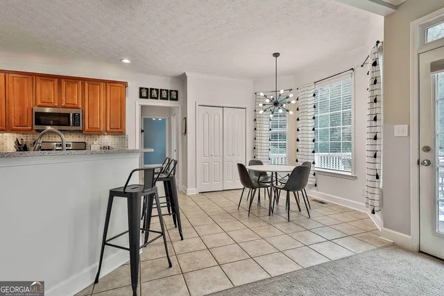 a living room with stainless steel appliances furniture a dining table and kitchen view