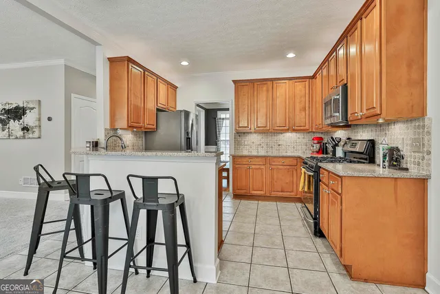 a kitchen with stainless steel appliances granite countertop a stove a sink dishwasher and a refrigerator