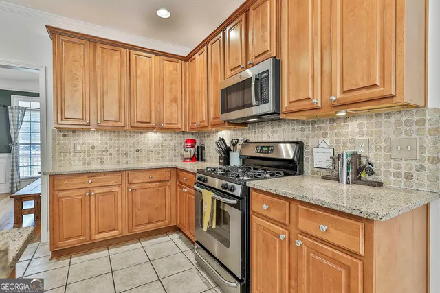 a kitchen with stainless steel appliances granite countertop a stove top oven a sink dishwasher and a refrigerator