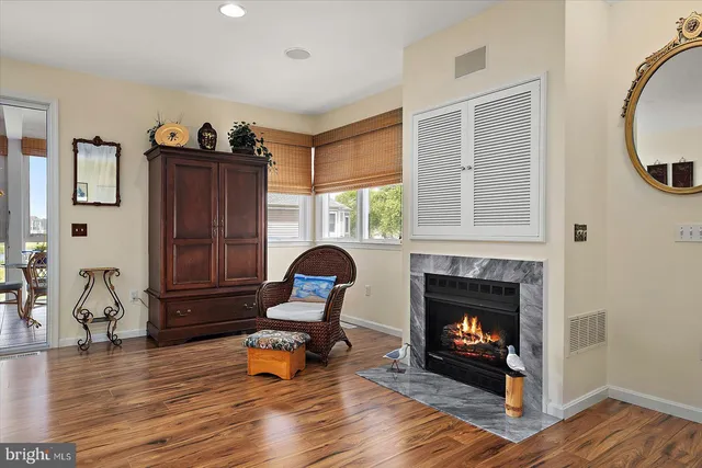 a kitchen with stainless steel appliances kitchen island granite countertop a stove top oven a sink dishwasher a dining table and chairs with wooden floor