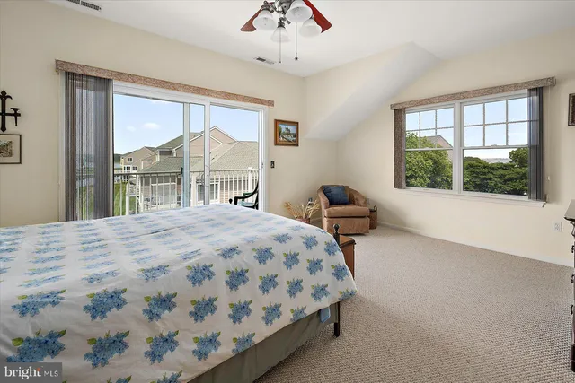 an aerial view of ocean and residential houses with outdoor space