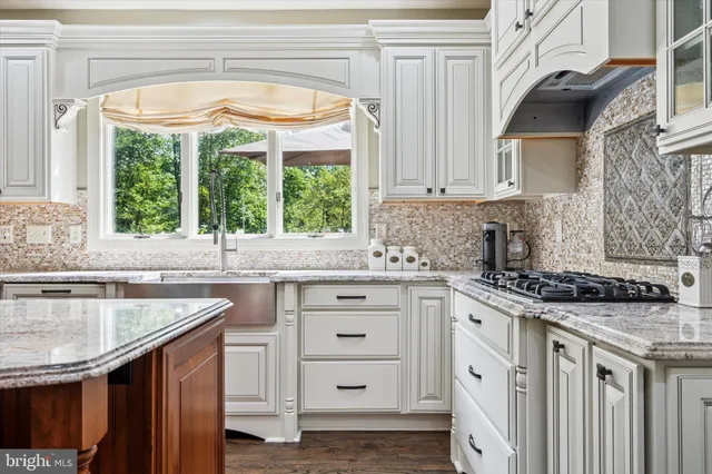 a kitchen with granite countertop a sink stove and cabinets