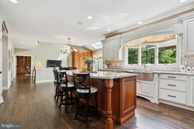 a kitchen with a table chairs sink and cabinets