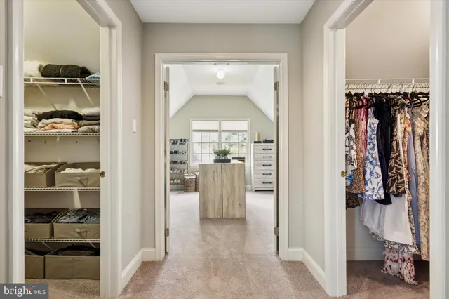 a view of walk in closet with clothes and shoes