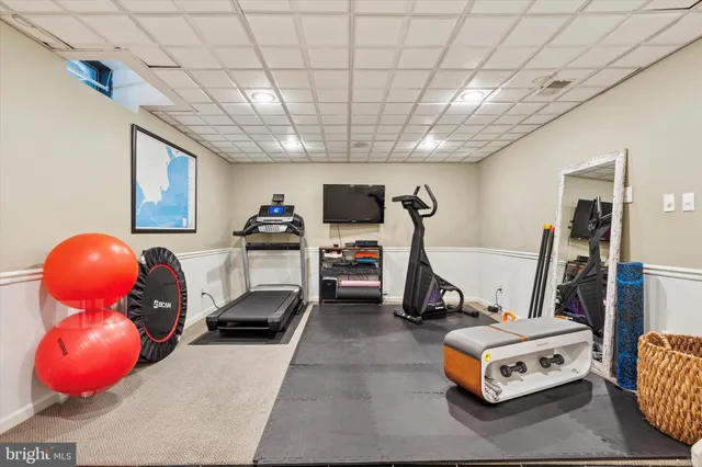 a room with gym equipment and furniture