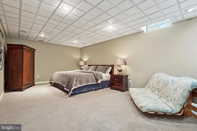 a spacious bedroom with a bed and a lamp