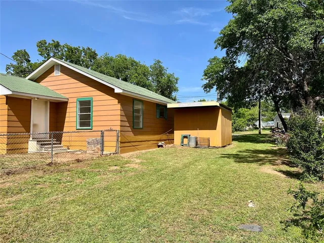 a backyard of a house with plants and tree