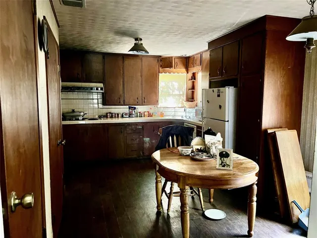 a kitchen with stainless steel appliances a sink a table and chairs
