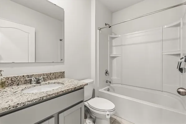 a bathroom with a granite countertop sink a toilet and shower