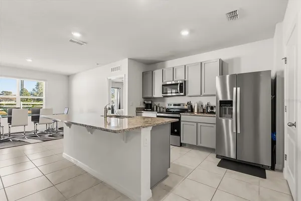 a kitchen with kitchen island a counter top space appliances and cabinets