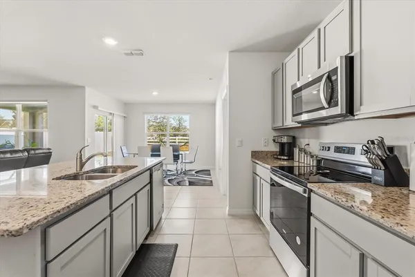a kitchen with stainless steel appliances granite countertop a sink stove and cabinets