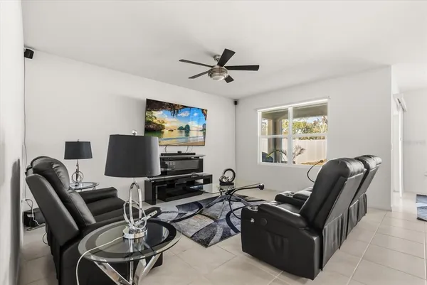 a work room with furniture a flat screen tv and a window