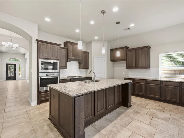 a kitchen with stainless steel appliances granite countertop a sink stove and oven