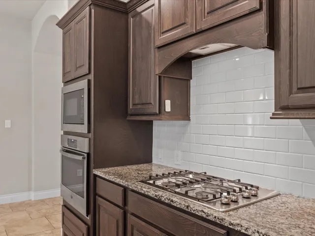 a kitchen with stainless steel appliances granite countertop a stove and a refrigerator