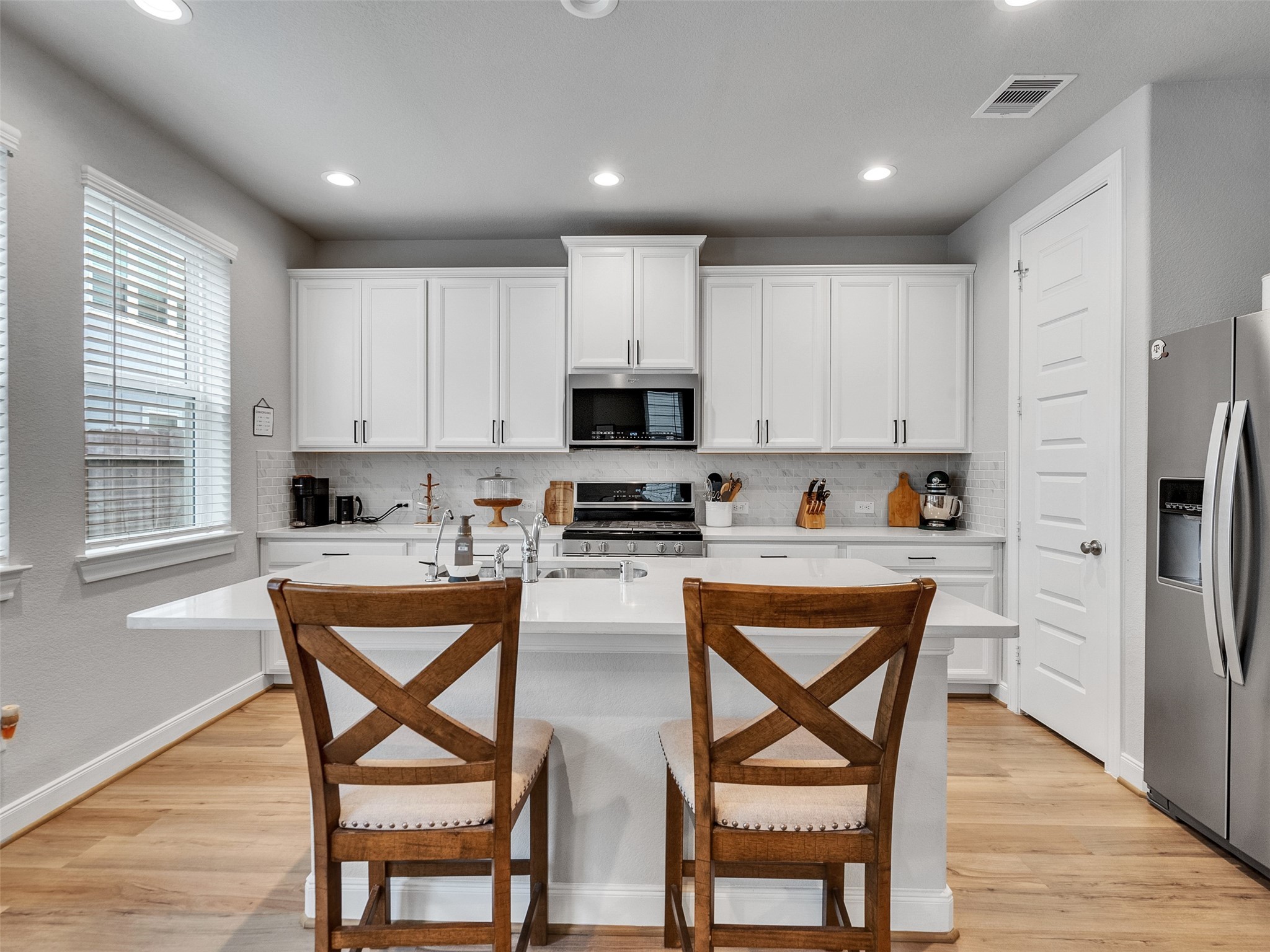 3118 Cloud Forest Lane Houston, TX 77080 - Photo 12 of 40 a kitchen with stainless steel appliances granite countertop a stove top oven a refrigerator a sink and a dining table with white cabinets