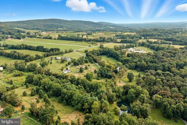 an aerial view of a residential houses with outdoor space and mountain view
