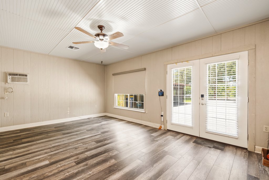 1961 Bolton Road Marion, TX 78124 - Photo 8 of 17 an empty room with wooden floor chandelier fan and windows