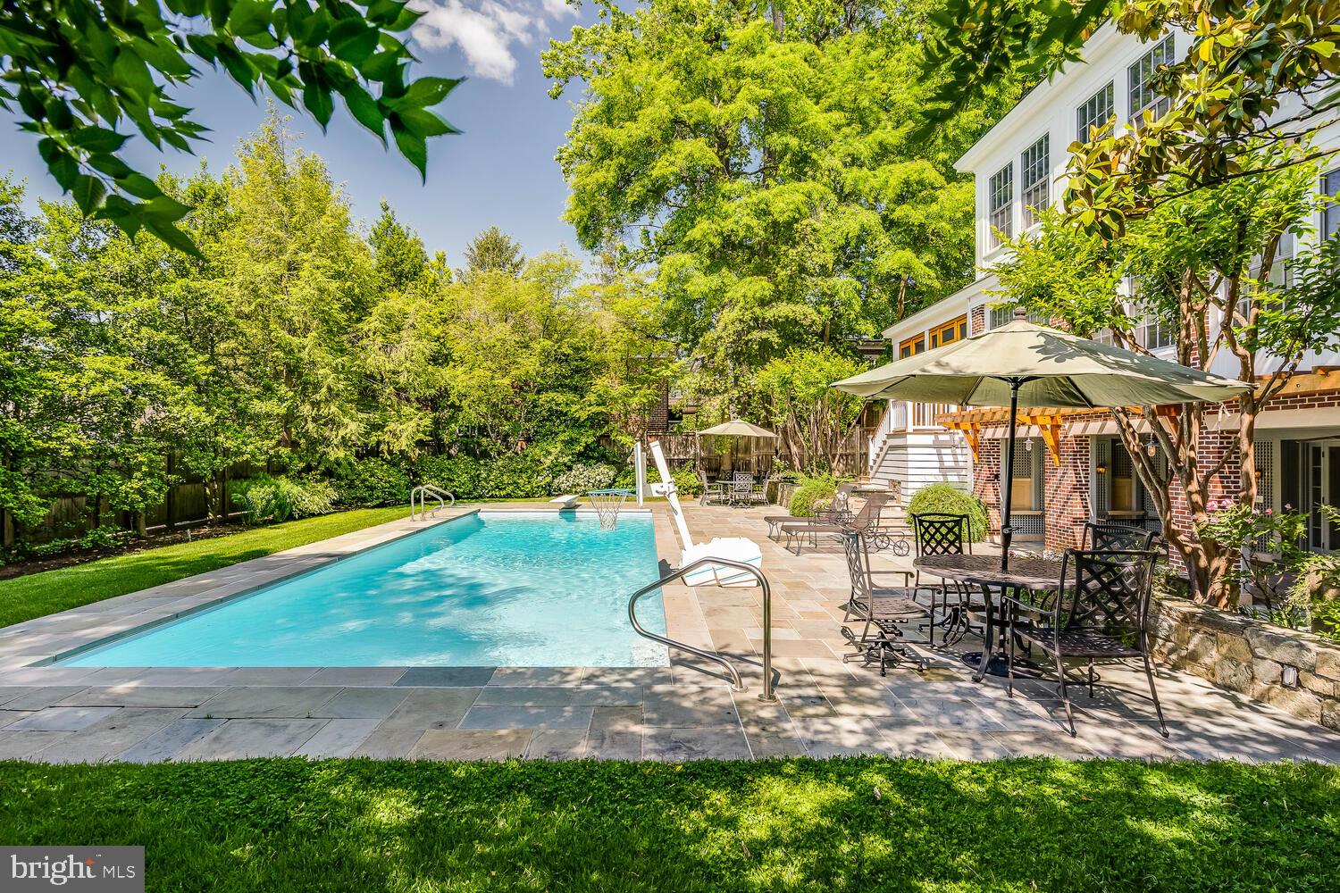3512 Rittenhouse Street Northwest Washington, DC 20015 - Photo 112 of 132 a backyard of a house with table and chairs under an umbrella