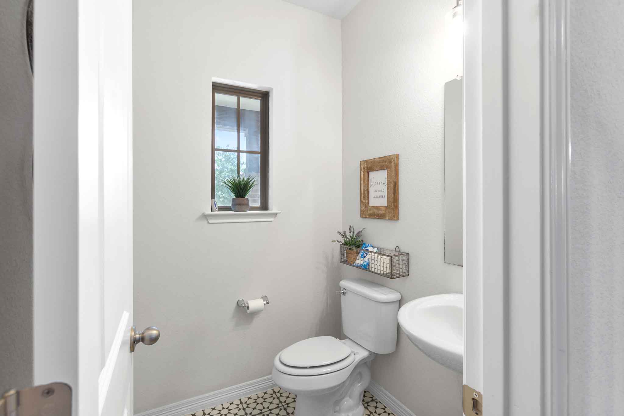 166 West Branch Road Kyle, TX 78640 - Photo 21 of 39 A compact and functional bathroom features a distinctive patterned floor and a window providing natural light.
