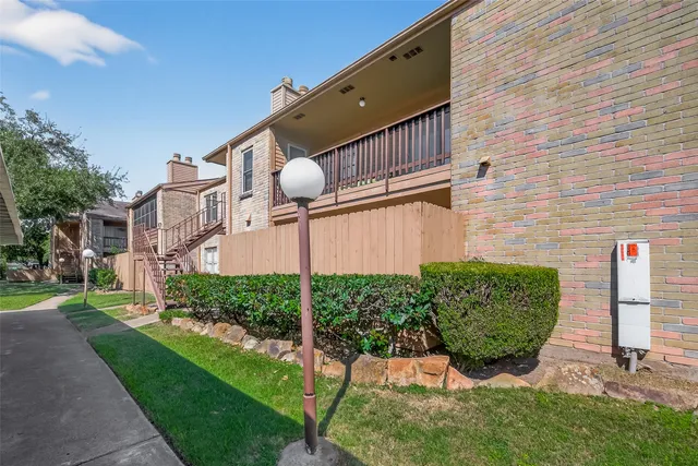 a view of a backyard with potted plants and a large tree