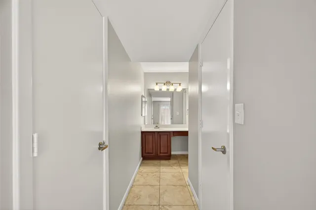 a view of a hallway with wooden floor and cabinet