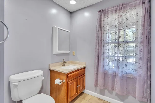 a living room with furniture and a dining table with kitchen appliances