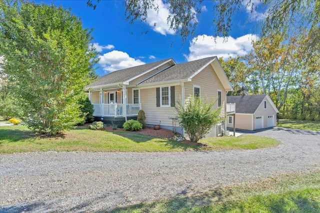 a backyard of a house with a yard and outdoor seating