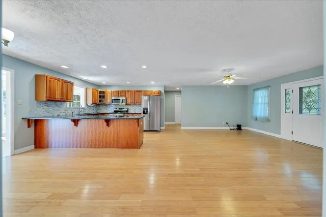 a kitchen with stainless steel appliances granite countertop a stove a sink and a microwave