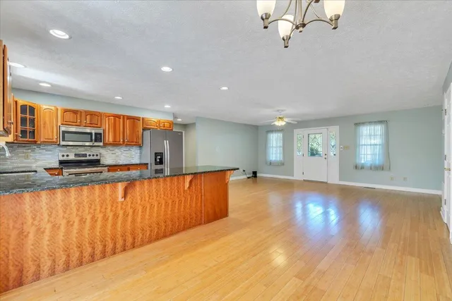 a kitchen with stainless steel appliances granite countertop a sink a window and a counter space