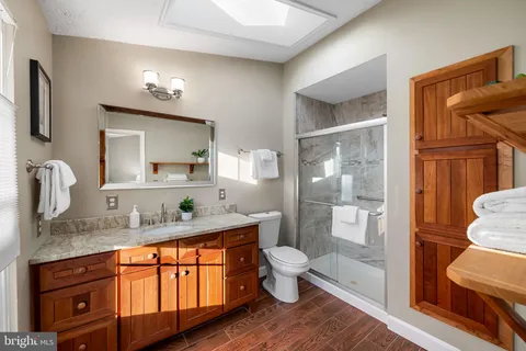 a spacious bathroom with a granite countertop sink toilet and shower