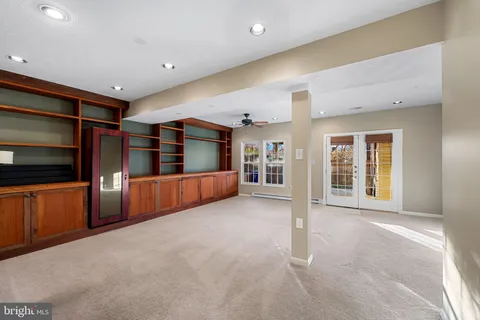 a view of an empty room with furniture and window