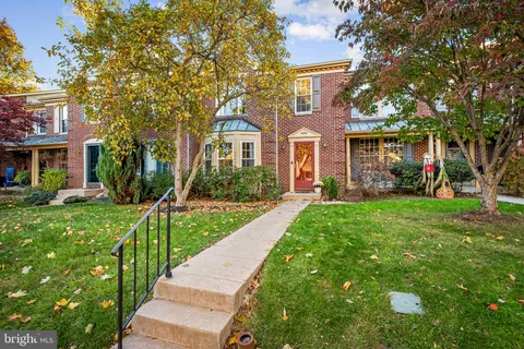 a front view of a house with a yard and trees
