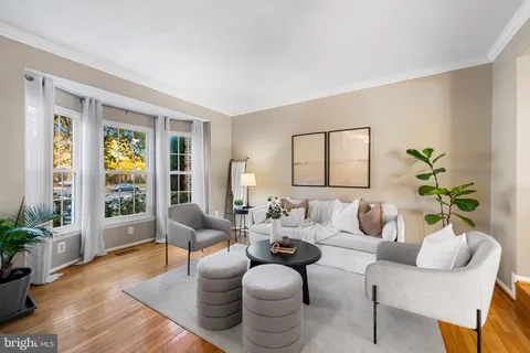 a living room with furniture potted plant and a large window