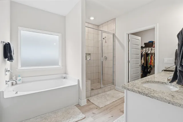a bathroom with a granite countertop sink a mirror and a bathtub