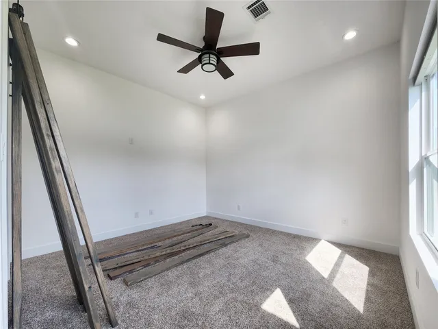 a view of room with window and a ceiling fan