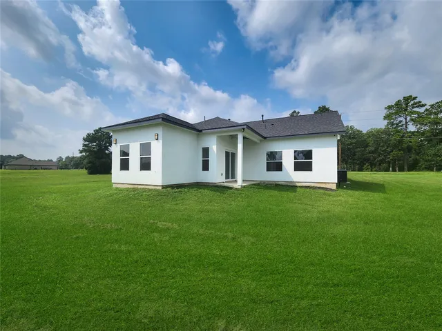 an aerial view of a house with a yard and lake view