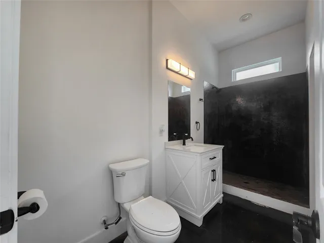 a bathroom with a toilet a sink a mirror and shower