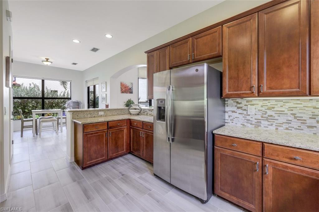 1276 Kendari Terrace Naples, FL 34113 - Photo 11 of 31 a kitchen with stainless steel appliances granite countertop a refrigerator a sink a stove and a microwave oven