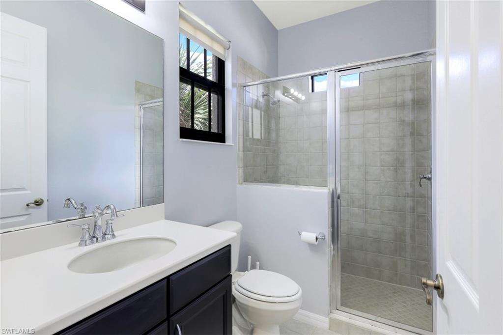 1276 Kendari Terrace Naples, FL 34113 - Photo 21 of 31 a bathroom with a granite countertop sink toilet a shower and a mirror