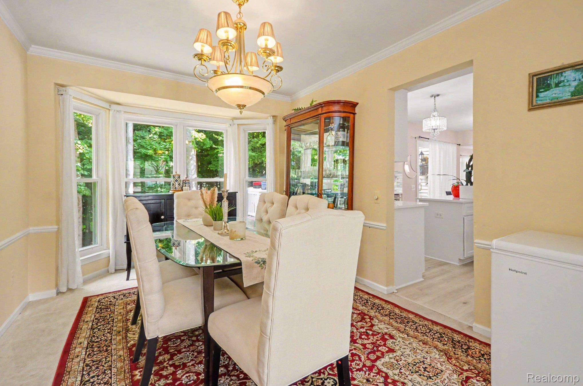 425 Thornridge Court Rochester, MI 48307 - Photo 13 of 35 Dining area featuring a bay window, crown molding, and chair rail detailing