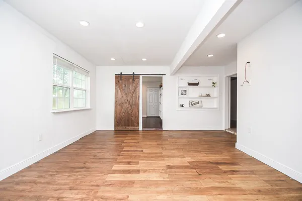a view of empty room with wooden floor