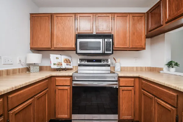 a kitchen with granite countertop a sink stove and microwave